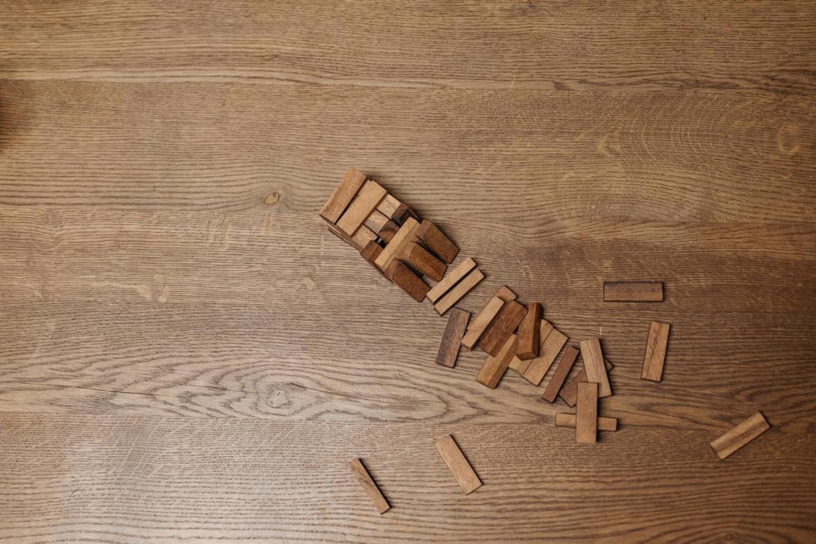 A fallen jenga tower on a wood surface