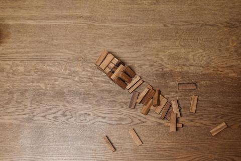 A fallen jenga tower on a wood surface
